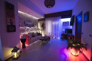 een woonkamer met een bank en paarse verlichting bij Dolce Conca D'Oro B&B in Palermo