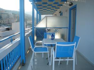 a balcony with a blue table and chairs on it at Ikonomakis Apartments in Balíon