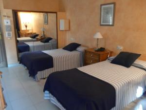 a hotel room with three beds and a mirror at Can Barrina in Montseny