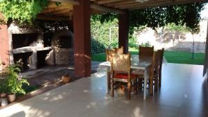 einen Tisch und Stühle auf einer Terrasse mit Kamin in der Unterkunft Casa en la Ruta del Vino in Mendoza