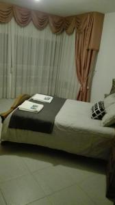 a bed sitting in a room with a window at Apartamentos Loyo in Portomarin
