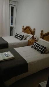 pokój z dwoma łóżkami i oknem w obiekcie Apartamentos Loyo w mieście Portomarin
