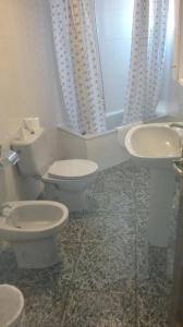 a bathroom with a sink, toilet, and bathtub at Apartamentos Loyo in Portomarin