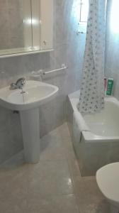 łazienka z umywalką i zasłoną prysznicową w obiekcie Apartamentos Loyo w mieście Portomarin