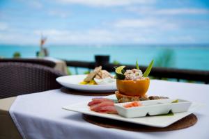 a table with two plates of food on it at Pacific Resort Aitutaki - Adults Only in Arutanga