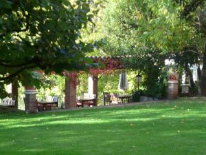 a garden with tables and chairs under a pergola at Can Barrina in Montseny