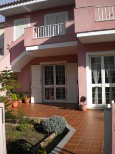 una casa rosa con un patio enfrente en Appartamenti Santa Teresa Gallura, en Santa Teresa Gallura