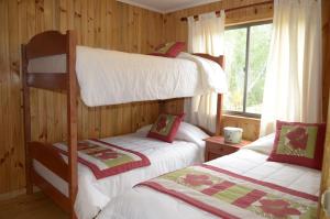 基利翁的住宿－Valle Paraiso，一间卧室设有两张双层床和一扇窗户。