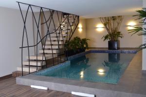 a swimming pool in a house with a staircase at Hotel 5 de Mayo in Puebla