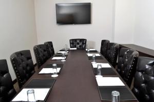 a conference room with a long table and black chairs at Hotel 5 de Mayo in Puebla +35 photos