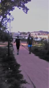 two people are walking down a sidewalk at Petite Callebasse in Cayenne