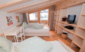 a small room with a bed and a desk at Chasa Seraina in Samnaun