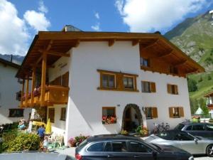 a white building with cars parked in front of it at Chasa Seraina in Samnaun