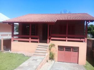 ein Haus mit einer roten Tür und einem roten Tor in der Unterkunft Del Fiore in Gramado