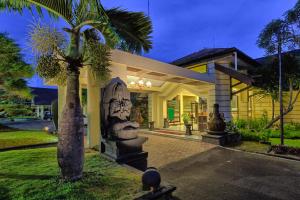 een huis met een standbeeld ervoor bij Hotel Montana Dua Malang in Malang