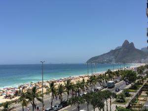a view of a beach with palm trees and the ocean at Flat Ipanema 2 Quadras da Praia - Estacionamento gratuito in Rio de Janeiro