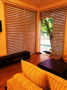 ein Wohnzimmer mit einem Sofa und einem großen Fenster in der Unterkunft Oak Residencies in Kiribathgoda