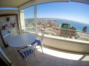 a table and chairs in a balcony with a view of the city at Vista Meseta Coraceros in Viña del Mar
