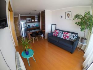 uma sala de estar com um sofá azul e uma cozinha em Vista Meseta Coraceros em Viña del Mar