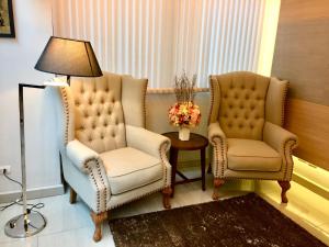 2 sillas y una lámpara en una habitación en Avatar Suites Hotel - SHA Extra Plus, en Bangkok