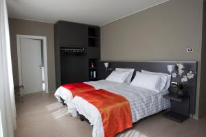 una camera da letto con un grande letto con una coperta rossa di Zara Rooms & Suites a Suzzara