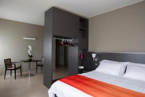 1 dormitorio con 1 cama grande, mesa y sillas en Zara Rooms & Suites, en Suzzara