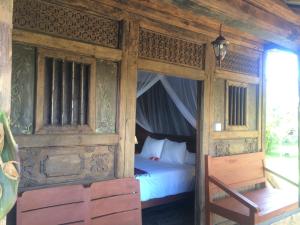 1 dormitorio con 1 cama en una habitación de madera en Soka Amed Beach en Amed
