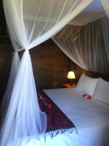 a bedroom with a bed with a white canopy at Soka Amed Beach in Amed