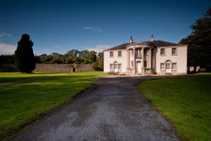 a large white house with a driveway at Culloden House Hotel in Inverness