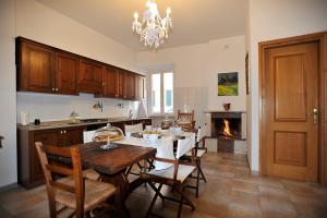 une cuisine avec une table et des chaises ainsi qu'une cheminée dans l'établissement La Fontana di Nonna Checchina, à Villa San Giovanni in Tuscia