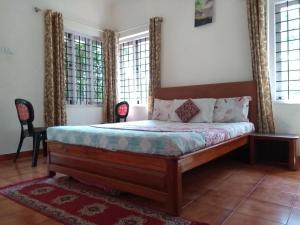 a bedroom with a bed in a room with windows at Coorg 4 C's Little Paradise in Madikeri