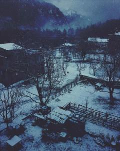 czarno-białe zdjęcie podwórza pokrytego śniegiem w obiekcie Orchards House - The Hidden Tribe w mieście Manāli
