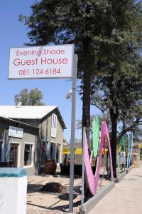 a sign for a guest house next to a building at Evening Shade in Omaruru