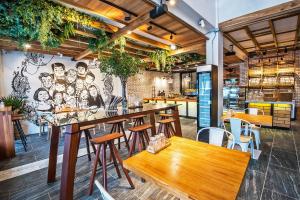 a restaurant with tables and chairs and a mural at Family Tree Hotel in Krabi