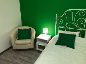 1 dormitorio verde con 1 cama y 1 silla en Simple Babushka House, en San Petersburgo