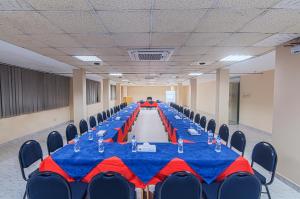 un largo salón de banquetes con mesas y sillas azules y rojas en Hotel Sea Crown, en Cox's Bazar