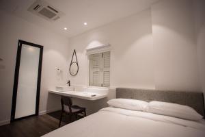 a bedroom with a bed and a sink and a mirror at The Southern Boutique Hotel in George Town