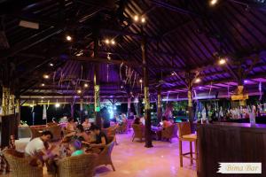 a group of people sitting in a bar at Adi Assri Beach Resorts And Spa Pemuteran in Pemuteran