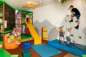 a room with children playing in a play room with a climbing wall at Hotel Tirolerhof in Flachau