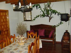 een eetkamer met een tafel en een bed en een televisie bij Casa Lopez in San Martín del Castañar