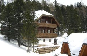 a large wooden house in the snow with trees at Haus Vucsina in Turracher Hohe