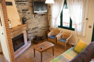 a living room with a couch and a fireplace at Hostal El Recanto in Vega de Valcarce
