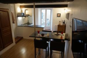 una pequeña cocina con mesa y sillas en una habitación en Appartement Larzilliere, en Saint-Mihiel