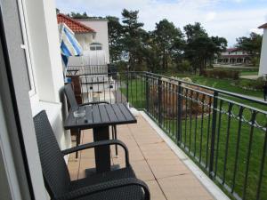 a balcony with two chairs and a table at Haus Meeresblick Wohnung A 1.04 in Baabe