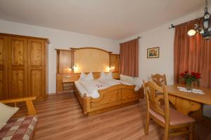 sypialnia z łóżkiem i biurkiem w pokoju w obiekcie Landhaus Lenzenhof w mieście Reit im Winkl