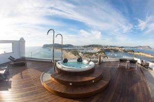 a hot tub on a deck with a view of the ocean at Hotel Cala Moresca in Bacoli
