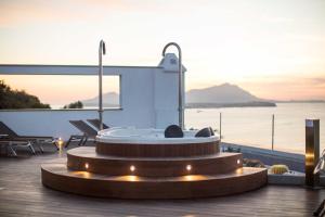 a hot tub on a deck with a view of the ocean at Hotel Cala Moresca in Bacoli