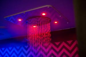 a pink and blue lights and a shower with a curtain at Hotel Cala Moresca in Bacoli