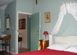 a bedroom with a bed and a sink in a room at Chambres d'hôtes Le Pont Romain in Montfort-le-Gesnois