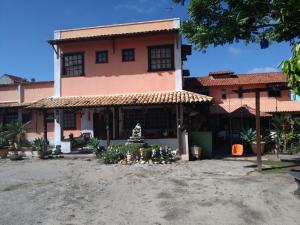 a house with a fountain in front of it at Pousada Casa D` Guio in Rio das Ostras